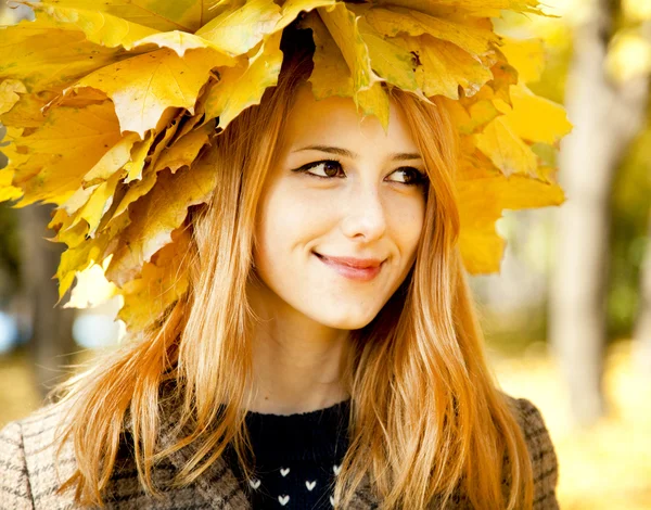 Mutlu kız gülümseyerek sonbahar yaprakları. — Stok fotoğraf