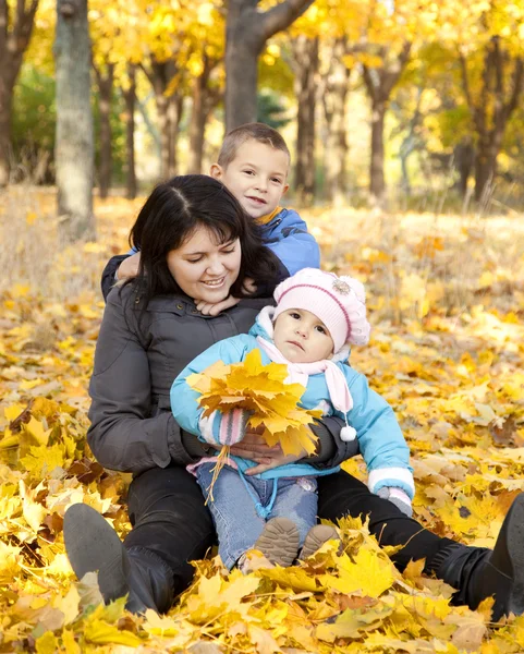 Mère et ses enfants jouent dans le parc d'automne — Photo