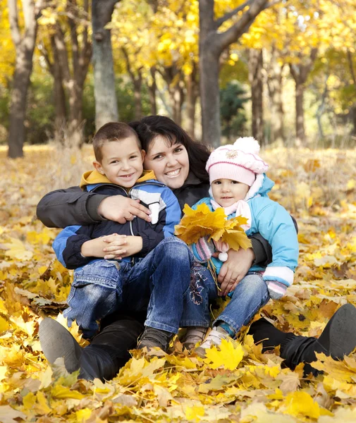 Mother and her childrens are playing in autumn park — Stock Photo, Image