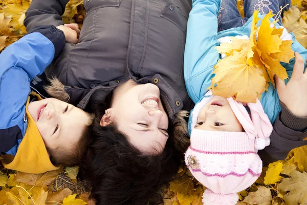 Mutter und ihre Kinder spielen im Herbstpark — Stockfoto
