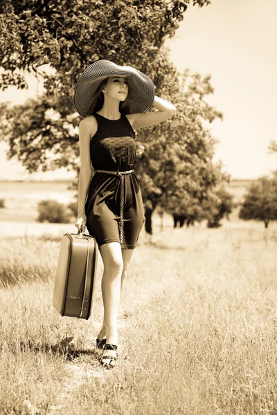Lonely girl with suitcase at countryside — Stock Photo, Image