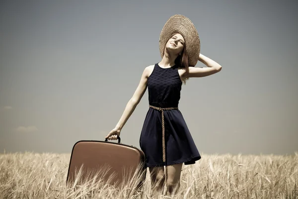 stock image Girl with suitcase at summer wheat field.