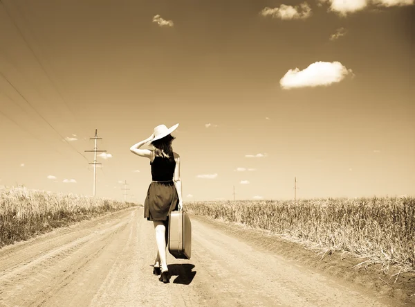 孤单的小女孩带着手提箱在乡村道路 — 图库照片