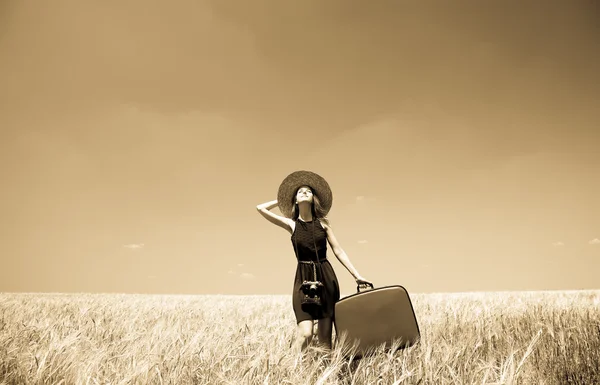 Girl with suitcase at summer wheat field. — Stock Photo, Image