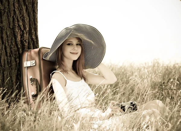 Meisje zit in de buurt van boom met vintage camera — Stockfoto