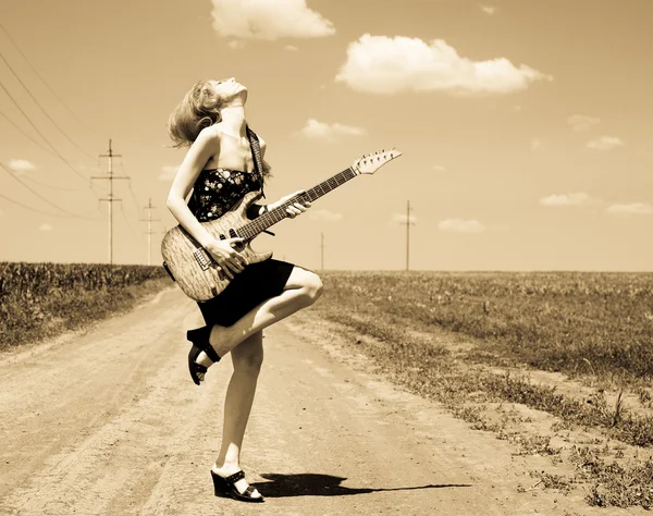 Menina de rock com guitarra no campo . — Fotografia de Stock