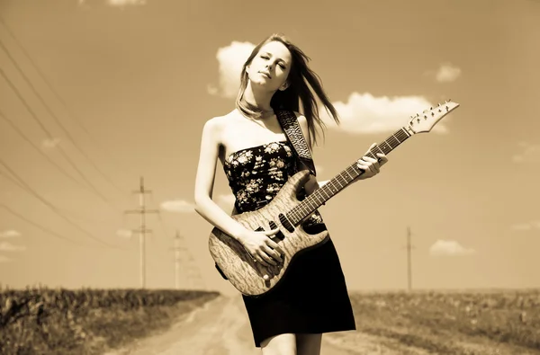 Rock flicka med gitarr på landsbygden. — Stockfoto