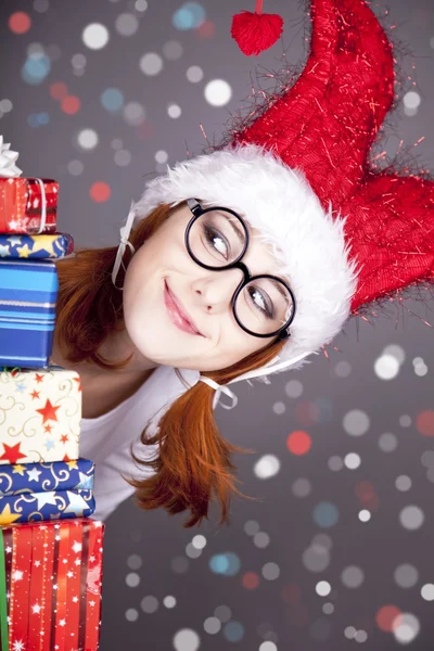 Engraçado menina ruiva em boné de Natal com caixas de presente . — Fotografia de Stock