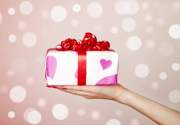 A box tied with a red satin ribbon bow. — Stock Photo, Image