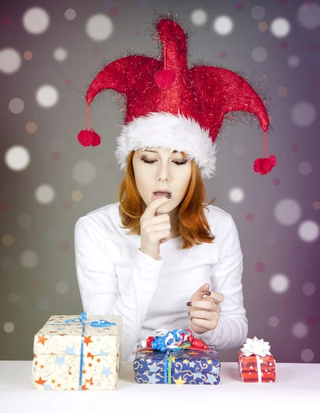 Смішна руда дівчина в різдвяній шапці з подарунковими коробками . — стокове фото
