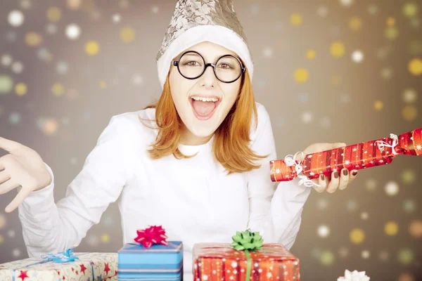 Chica en gorra de Navidad y vasos con cajas de regalo . —  Fotos de Stock