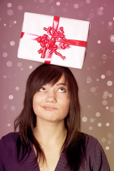 Beautiful brunette girl with present box over head. — Stok fotoğraf