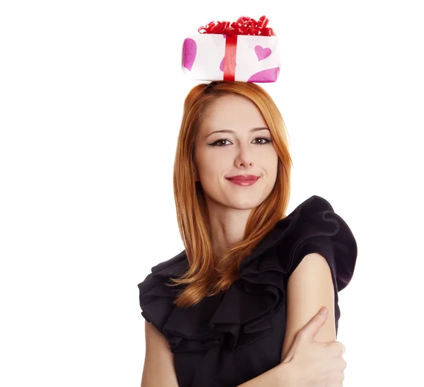 Красивая рыжая девушка с коробкой подарков над головой . — стоковое фото
