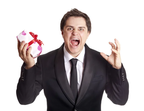A angry man holding present box in formal black tux — Stock Photo, Image