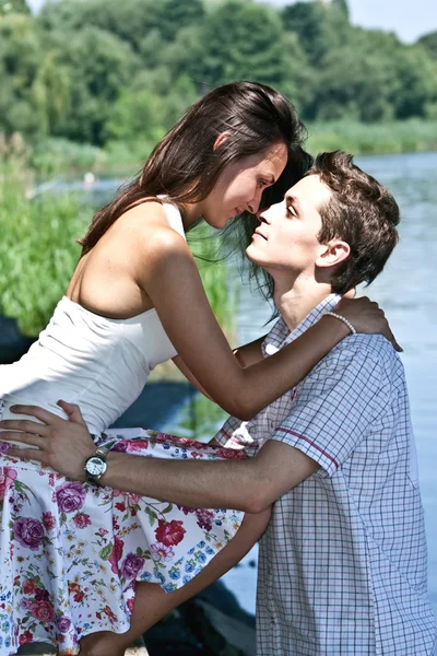 Мужчина и женщина целуются на берегу реки — стоковое фото