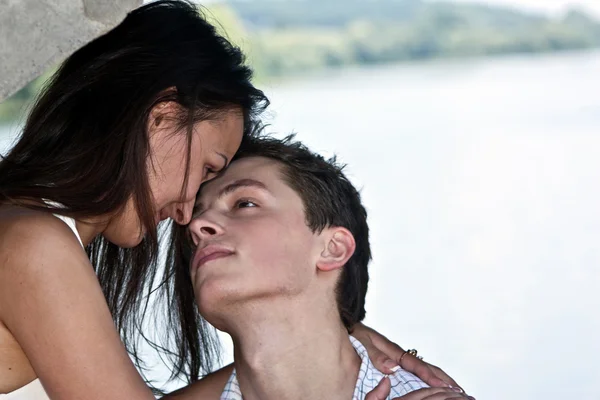 Schöner Mann und die Frau küssen sich am Ufer des Flusses unter dem — Stockfoto