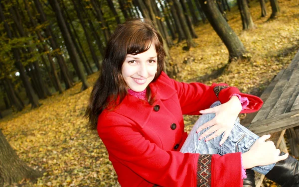 Η σεμνή γυναίκα χαρούμενη σε ένα κόκκινο παλτό — Φωτογραφία Αρχείου