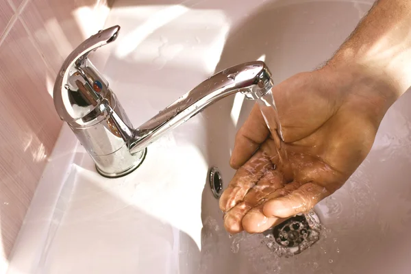 Моет руки под краном — стоковое фото