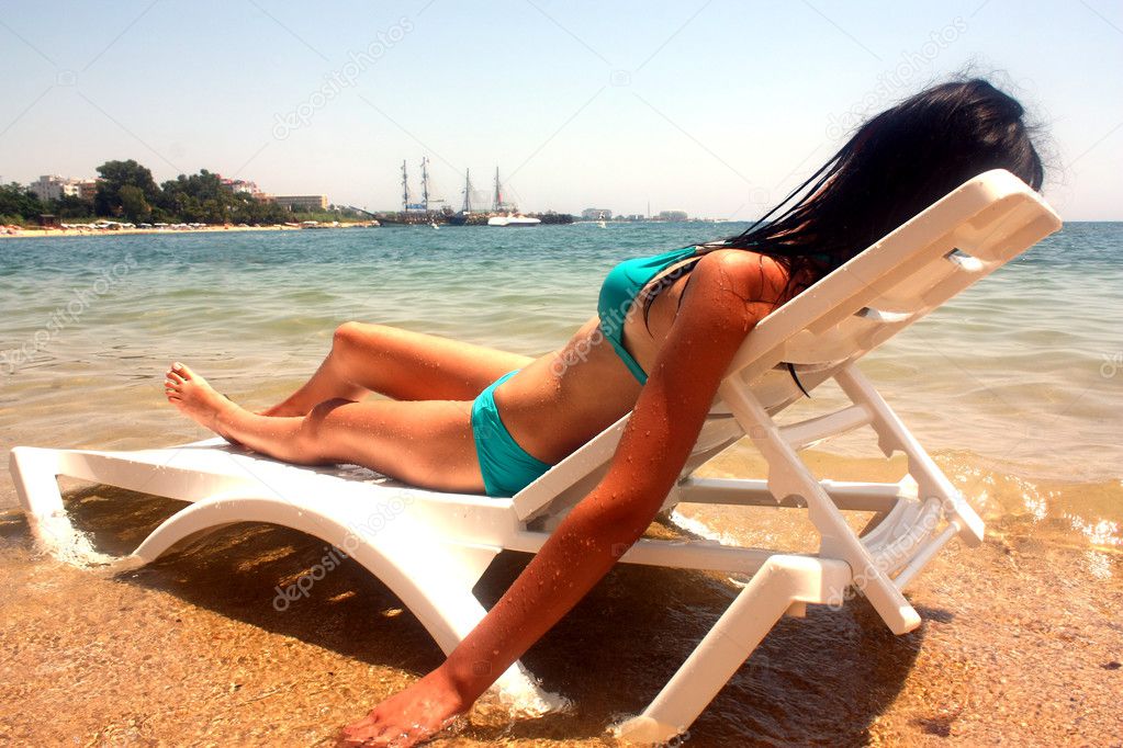 The woman in a bathing suit which has a rest lying on an armchai