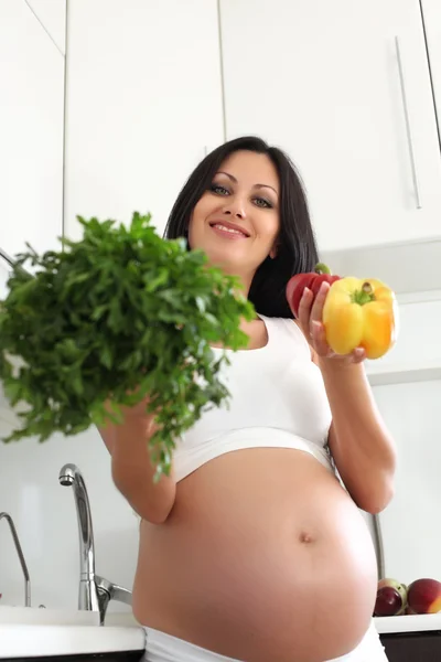 Pregnant woman in kitchen Stock Photo
