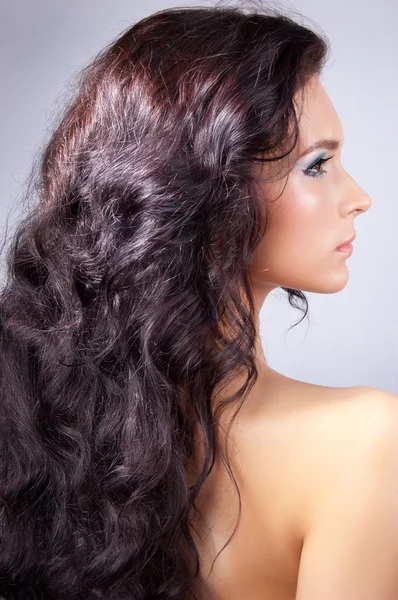 Mladá žena s dlouhými kudrnatými vlasy — Stock fotografie