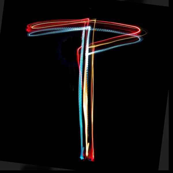 Letra T hecha de luces de neón de colores brillantes —  Fotos de Stock