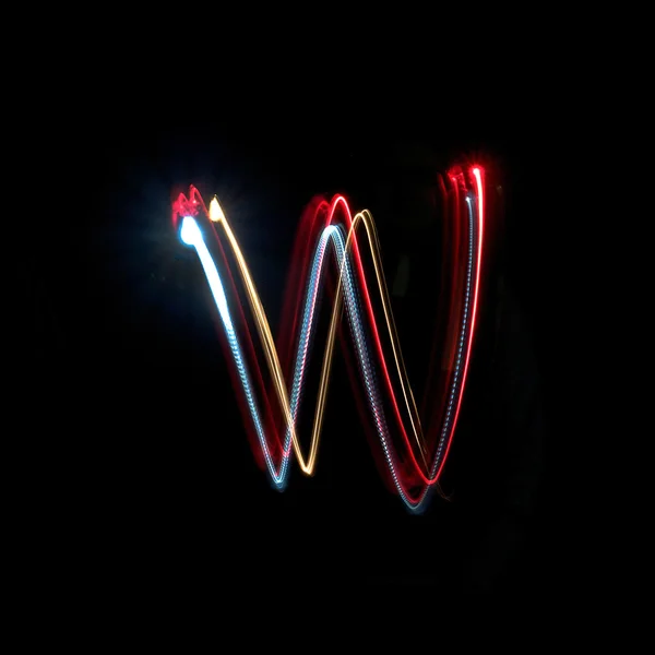 Letter W made from brightly coloured neon lights