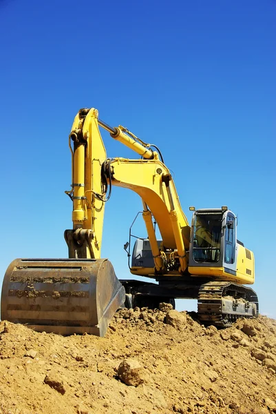 Gul grävmaskin på en arbetsplattform — Stockfoto