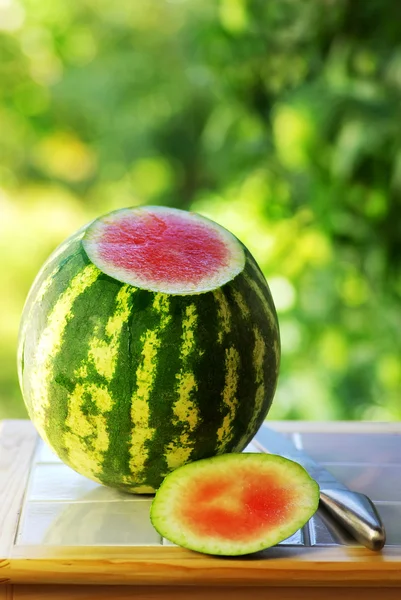 Watermeloen en mes op tafel. — Stockfoto