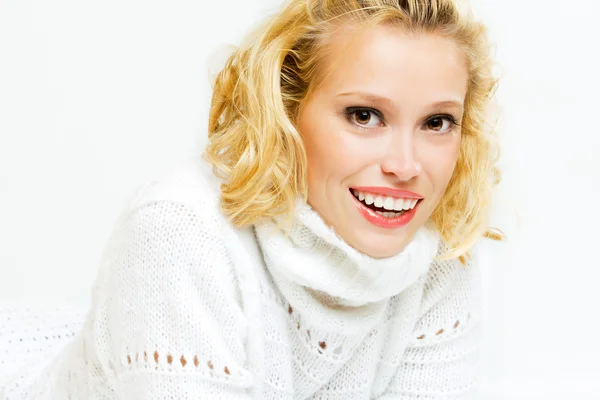 Улыбающаяся блондинка в белом свитере — стоковое фото