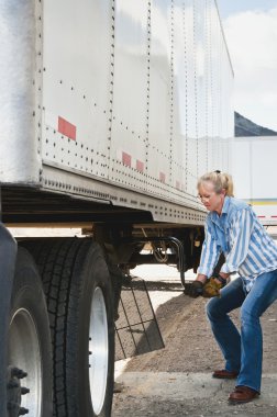 Woman Truck Driver Raising Trailer legs clipart