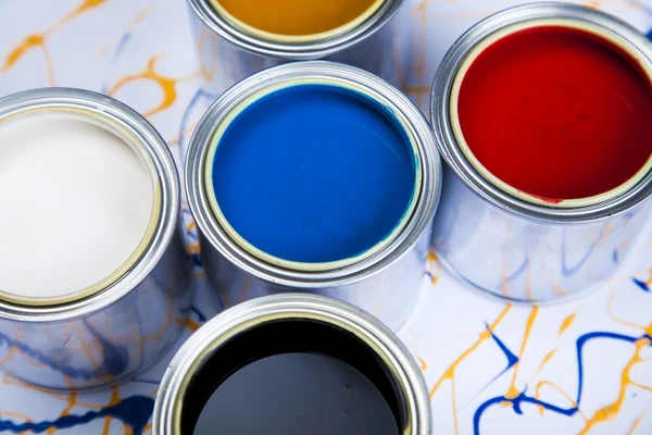 Cans and paint on the colourful background — Stock Photo, Image