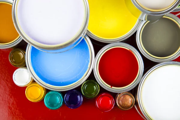 Latas e tinta sobre o fundo colorido — Fotografia de Stock