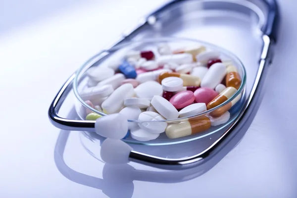 Tabletták csendélet és sztetoszkóp — Stock Fotó