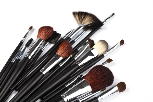 Set med professionell makeup borstar på vit bakgrund — Stockfoto