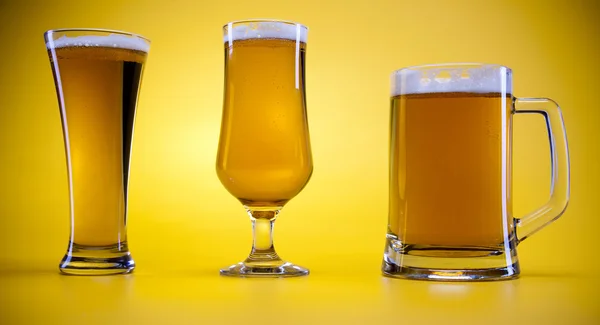 Sarı arka plana sahip bira cam — Stok fotoğraf