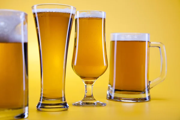Стекло пива с желтым фоном — стоковое фото