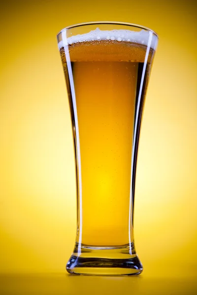 Sarı arka plana sahip bira cam — Stok fotoğraf