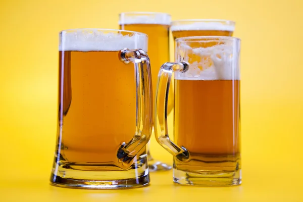 Bicchiere di birra con sfondo giallo — Foto Stock