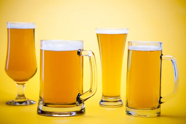 Стекло пива с желтым фоном — стоковое фото
