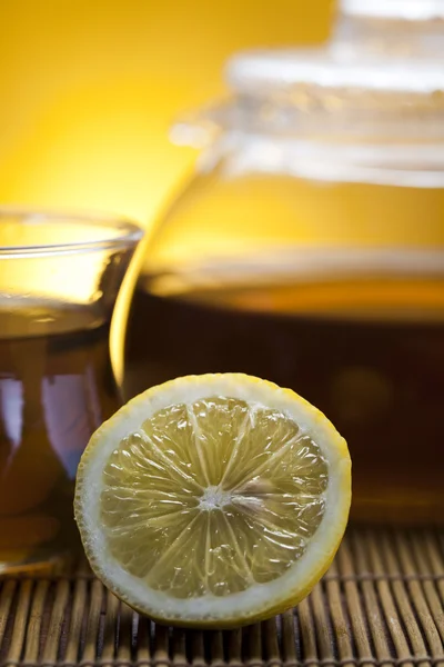 stock image Glass teapot of tea with lemon