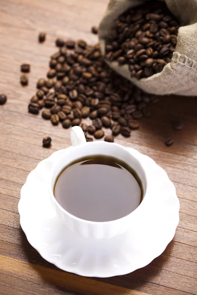 Coffee over dark roasted coffee beans — Stock Photo, Image