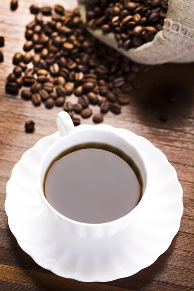 Coffee over dark roasted coffee beans — Stock Photo, Image