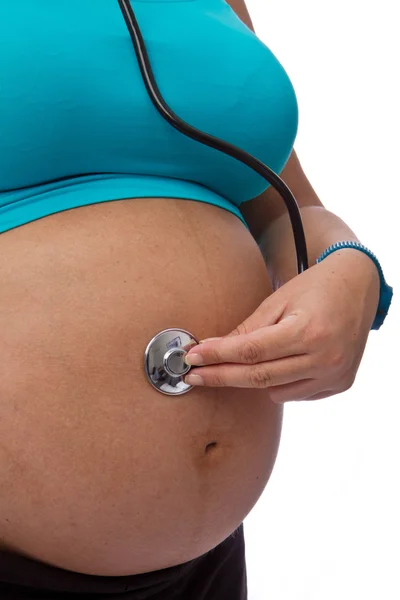 Mujer embarazada escuchar con un estetoscopio — Foto de Stock