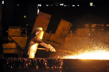 Worker using torch cutter to cut through metal clipart