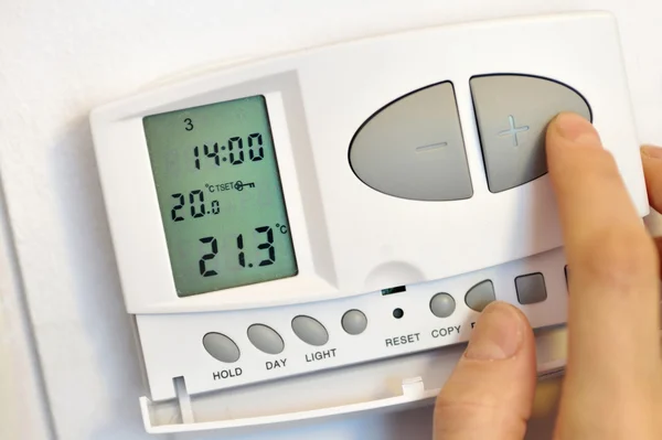 Ręcznie naciskając przycisk na cyfrowy termostat — Zdjęcie stockowe