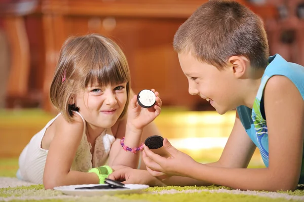Boy and girl playing with cookies — Stock Photo, Image