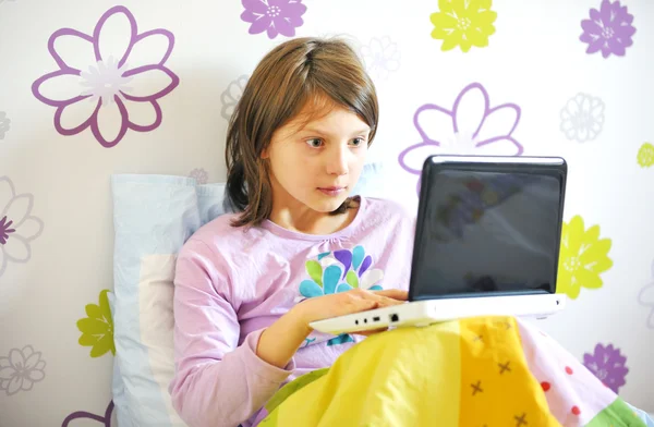 Verrast meisje met laptop in haar bedlaptop yatağında sürpriz kızla — Stok fotoğraf