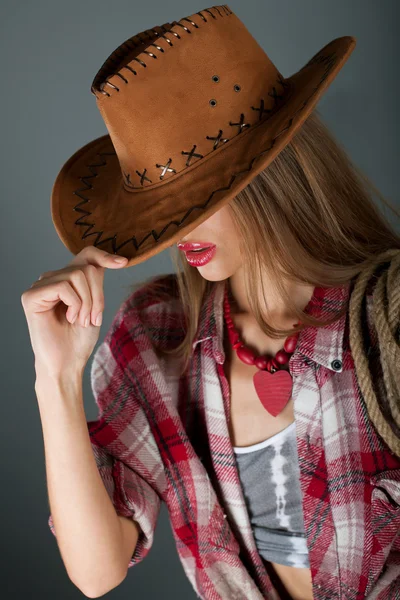 美丽的年轻女孩的嘴唇微笑下的棕色帽子 — 图库照片