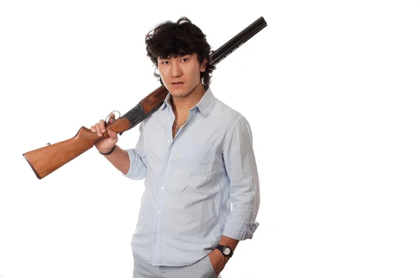 Азиат с пистолетом на белом комоде — стоковое фото